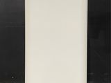 a white refrigerator sitting on top of a counter next to a black wall