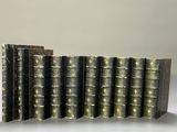 several old books are lined up in a row on a table