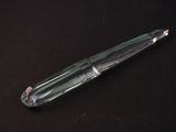 un stylo en verre posé sur une surface noire