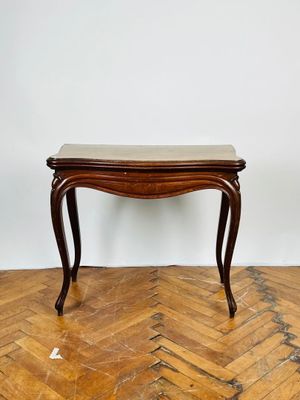 une photo d'une table en bois avec un plateau en marbre posée sur un parquet