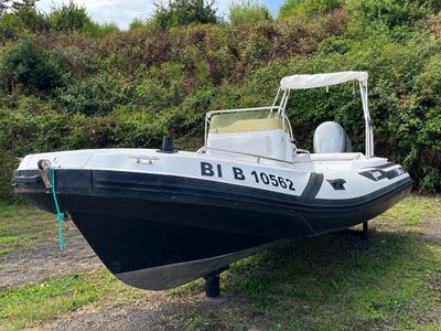 a black and white boat sitting on the grass