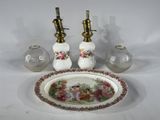 une assiette blanche ornée de fleurs, à côté de deux lampes à huile et d'une assiette décorée d'un motif floral