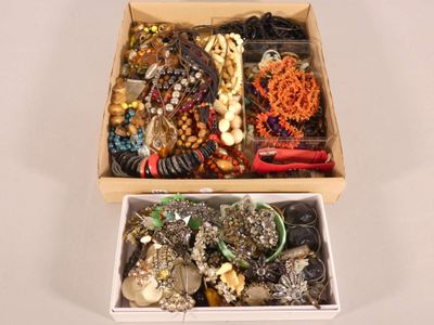 two boxes of assorted jewelry sitting on a table