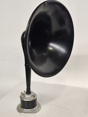 une enceinte noire posée sur une table blanche