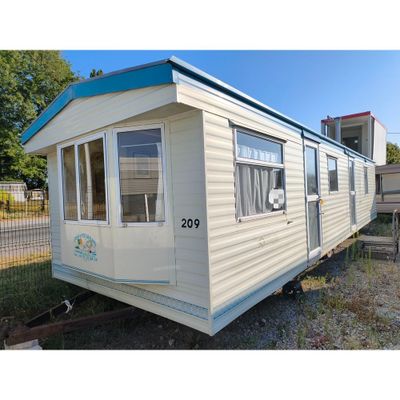 une photo d'un mobil-home garé dans l'herbe