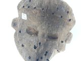 a wooden mask with holes in it on a white surface