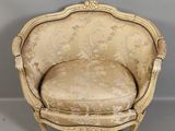 une vieille chaise dont l'assise est recouverte d'un tissu doré