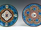 two plates with designs on them are sitting side by side