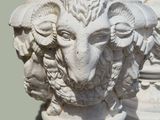 a statue of a ram with a head of flowers on it
