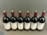 six bottles of wine are lined up in a row on a table