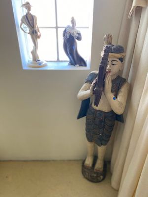 a statue of a man holding a gun in front of a window