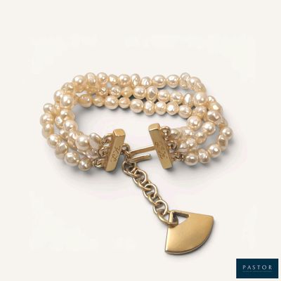 bracelet en perles orné d'une breloque en forme de cœur en or et d'une autre breloque en forme de cœur