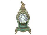 une horloge surmontée d'un oiseau, sur fond blanc