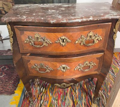 une petite commode en bois avec un plateau en marbre
