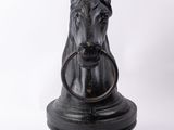 statue of a horse with a ring in its mouth on a white background