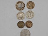 several different coins are arranged in a row on a white surface