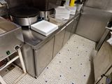 une cuisine avec de nombreux plans de travail en inox