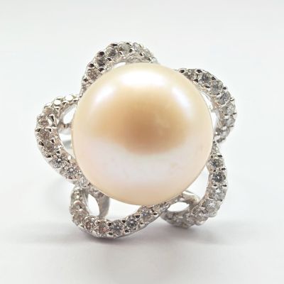 une image d'une bague en perles et diamants sur fond blanc