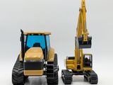 two toy construction vehicles that are sitting next to each other