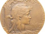 an image of a gold medal with a woman ' s face on it