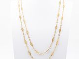 a gold necklace with three layers of chain and a gold disc