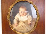 une vieille photo d'un bébé dans un cadre en bois