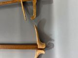 two wooden tools hanging on the wall next to each other