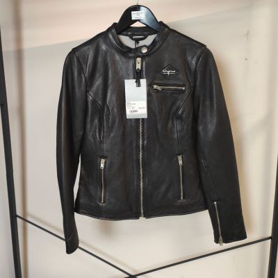 une veste en cuir noir suspendue à un portant dans un magasin