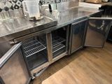a stainless steel counter with a bunch of bottles on top of it