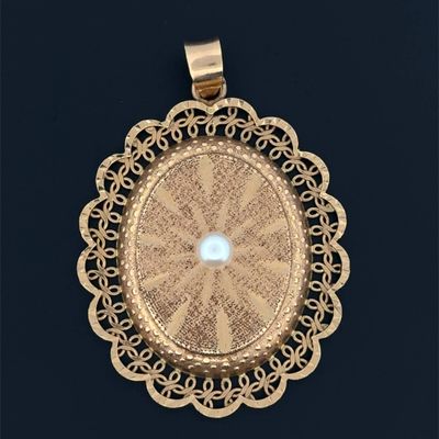an image of a gold pendant with a pearl in the center