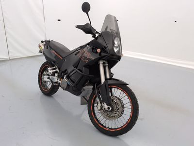 une moto noire garée dans une pièce aux murs blancs