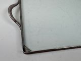 a silver tray with a mirror on it on a table