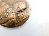 une médaille d'or avec la photo d'une femme dessus