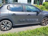 grey car parked on the side of the road in front of a building