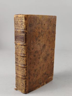 an old book sitting on top of a table next to a white wall