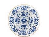 une assiette bleue et blanche décorée de fleurs et de feuilles
