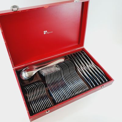 a red box with silverware in it on a white surface