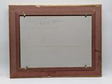 an old picture frame with writing on it sitting on top of a table