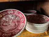 several red and white plates are stacked on a yellow table cloth