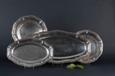 three silver trays sitting on top of each other next to a leaf