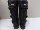 pair of black motorcycle boots with red logos on them sitting on a table