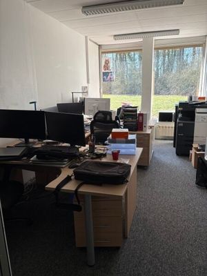 une salle où se trouvent de nombreux bureaux et ordinateurs