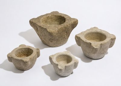 quatre morceaux de pierre sont disposés en ligne sur une surface blanche