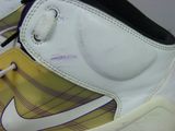 a close up of a pair of shoes with a yellow and white design