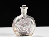 une petite bouteille en verre ornée d'un motif floral