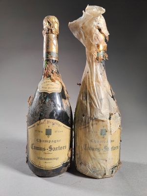deux bouteilles de champagne posées l'une à côté de l'autre sur une table