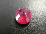 a close up of a red ruby stone on a black surface
