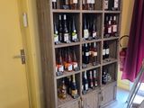a tall wooden cabinet with many bottles of wine on it