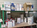 de nombreux pots de peinture posés sur une étagère dans un garage