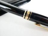 a pen that is sitting on a table next to a wallet